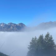 Nebel in den Bergen, der sich lichtet, über dem Nebel strahlend blauer Himmel. Das bild steht für die Wirkung des medialen Coachings. Birgit Herrscher, Feinstoffliche Energiearbeit.